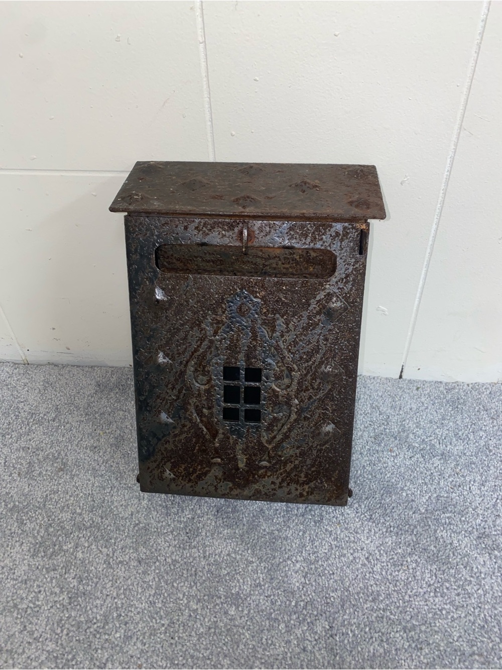 Antique hand-forged and rusted metal wall-mounted mailbox